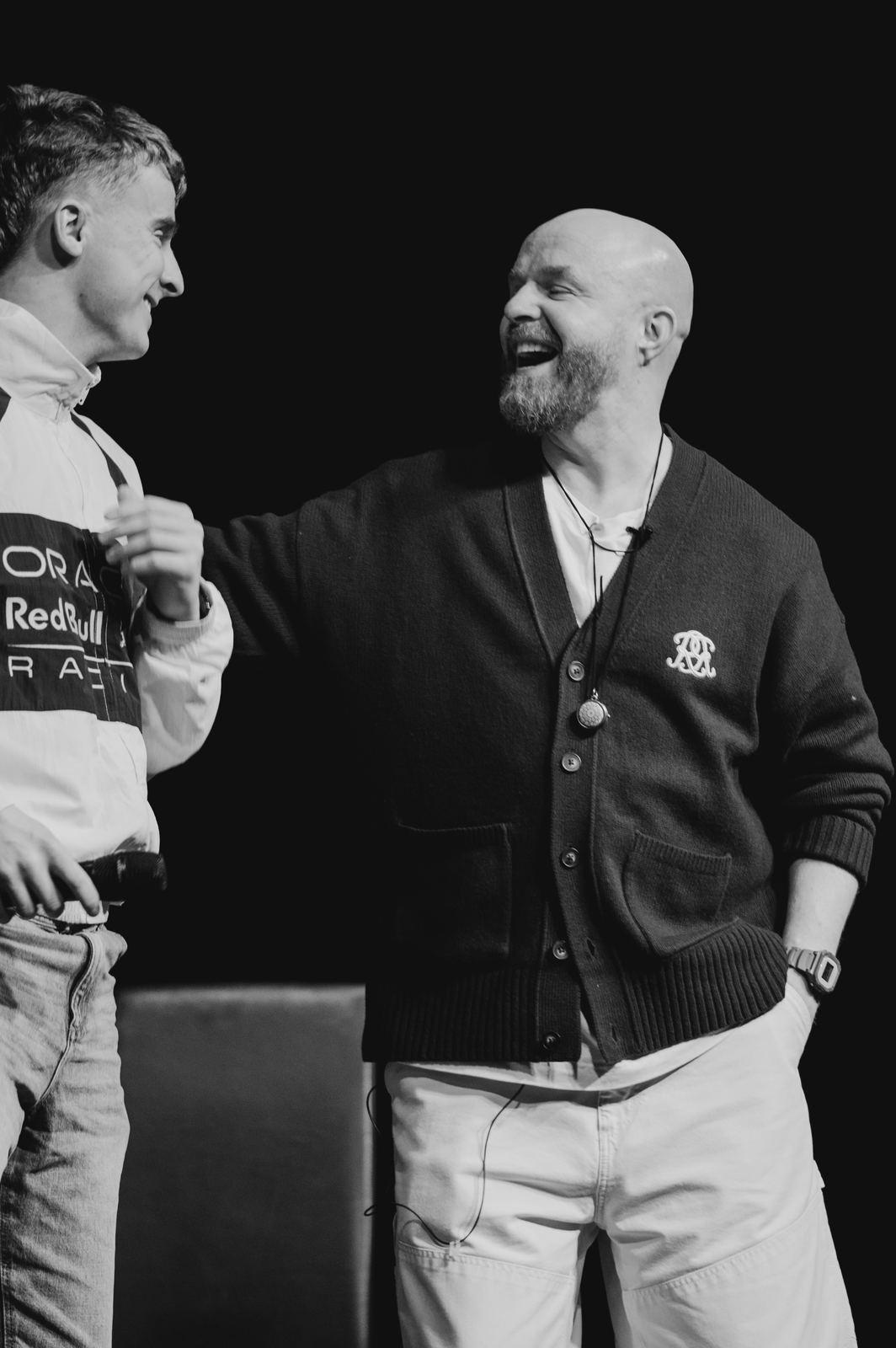 Luke Staton laughing with a guest on stage.
