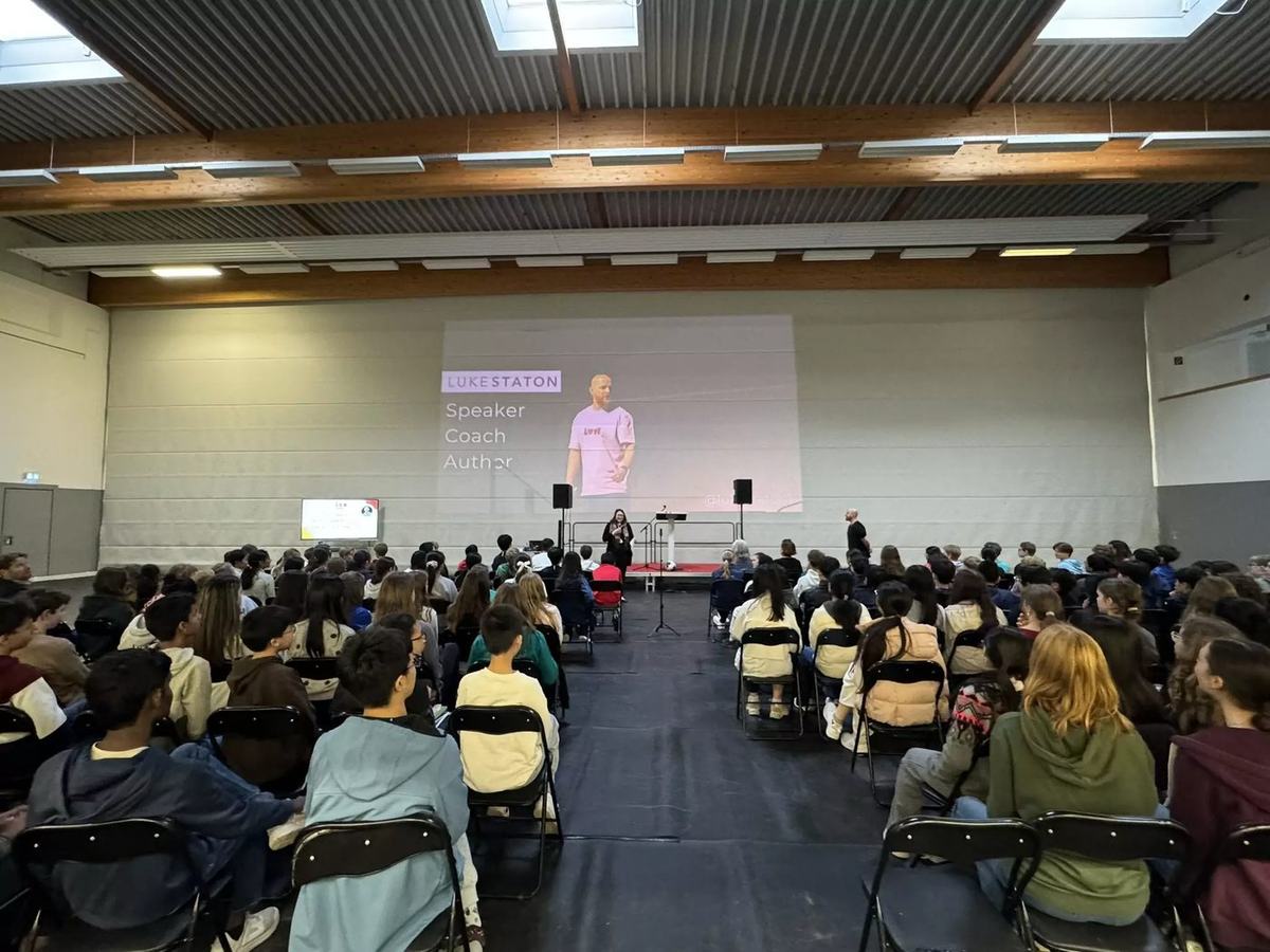A full sports hall of students at ISR International School on the Rhine.