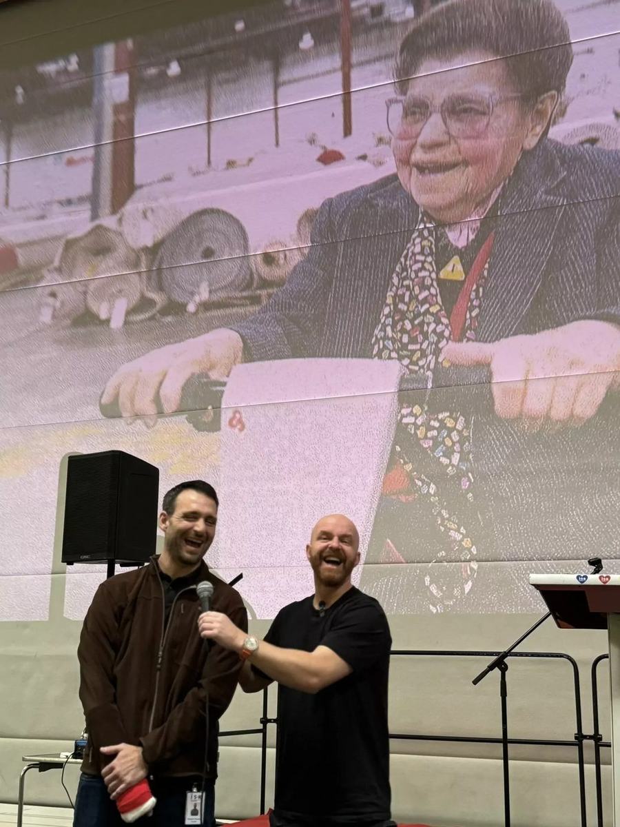 Luke Staton laughing on stage with a teacher at ISR.
