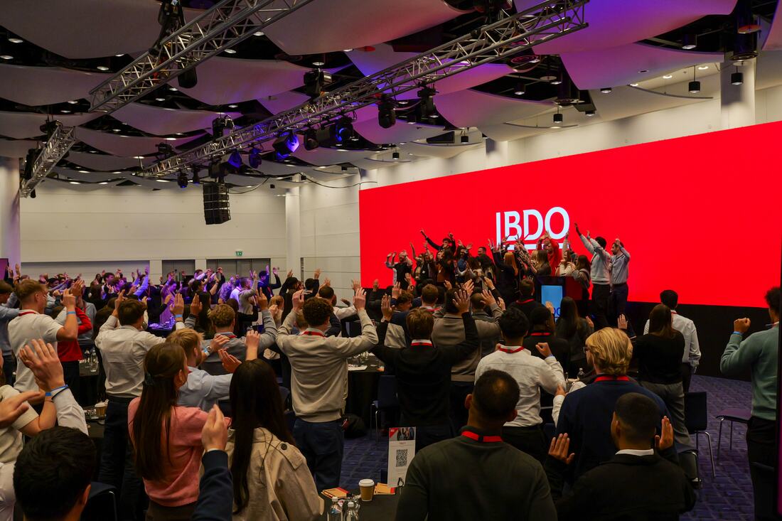 BDO graduates on their feet, arms in the air, at Wembley.